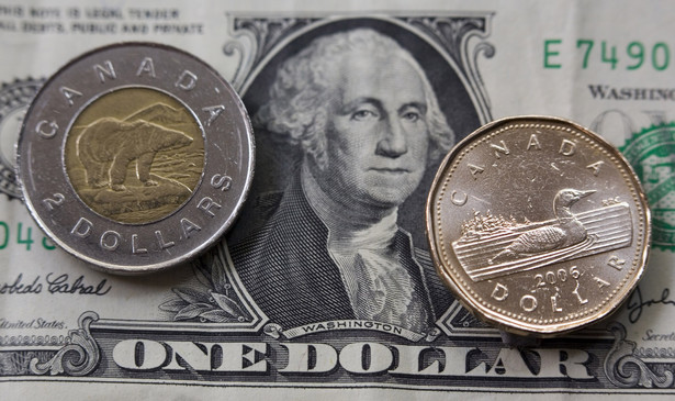 Monety kanadyjskie - dwudolarowa "Tooney" i jednodolarowa "Loonie" - na tle banknotu jednego dolara amerykańskiego. Fot. Bloomberg