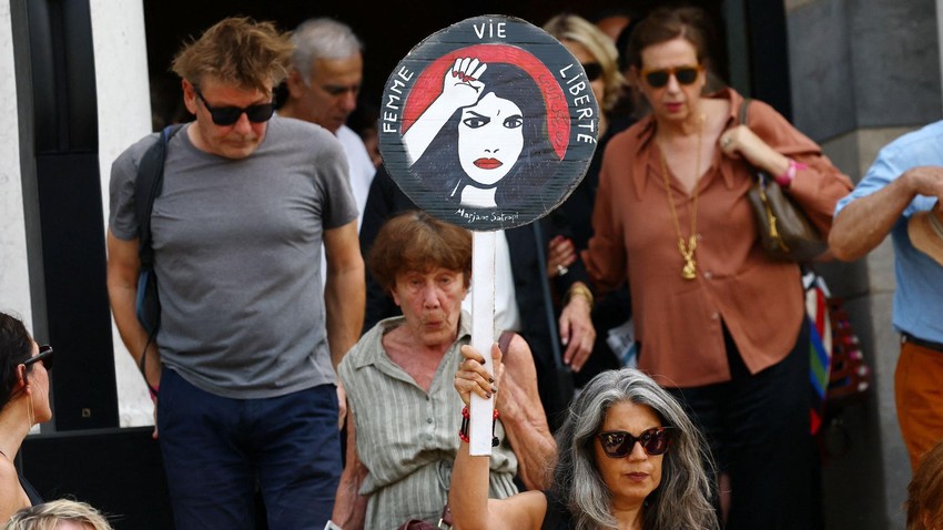Plakat sa likom Marđan Satrapi na njenoj sahrani i porukom „žene, život, sloboda" | Foto: Reuters