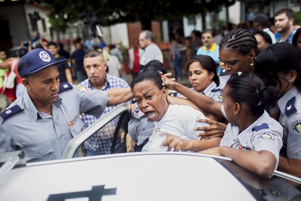 Cuban security personnel detain a member of the Ladies in White dissident group during a protest on 