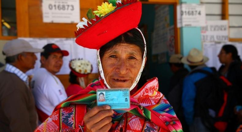 A voter in Ollantaytambo, near the ancient imperial Inca capital of Cuzco, shows her identity card as Peruvians voted on constitutional reforms aimed at curtailing corruption