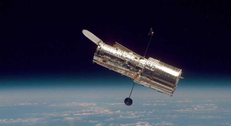 The Hubble Space Telescope hovers at the boundary of Earth and space in this picture, taken after Hubble's second servicing mission in 1997.
