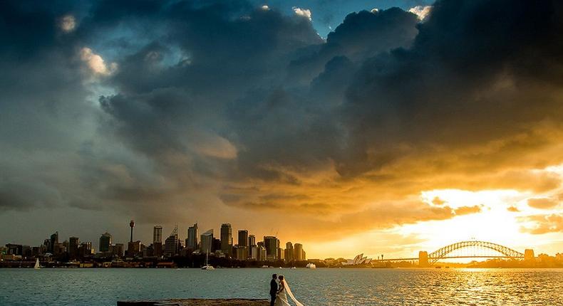 Photographer Sam Yeldham captured the clouds parting for a picture perfect minute behind the happy newlyweds (pictured)