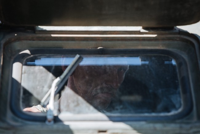 Ukraiński żołnierz wygląda przez okno wojskowego pojazdu w czasie przejazdu przez okolice Samozwańczej Republiki Doniecka.