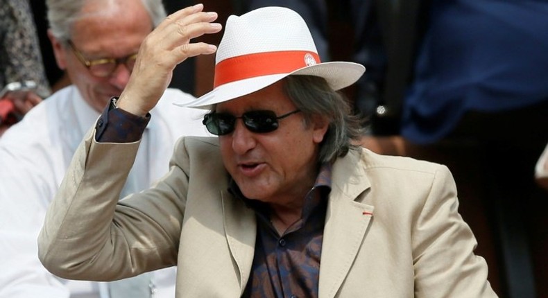 Romanian former tennis player Ilie Nastase salutes the crowd at the French Open in 2013