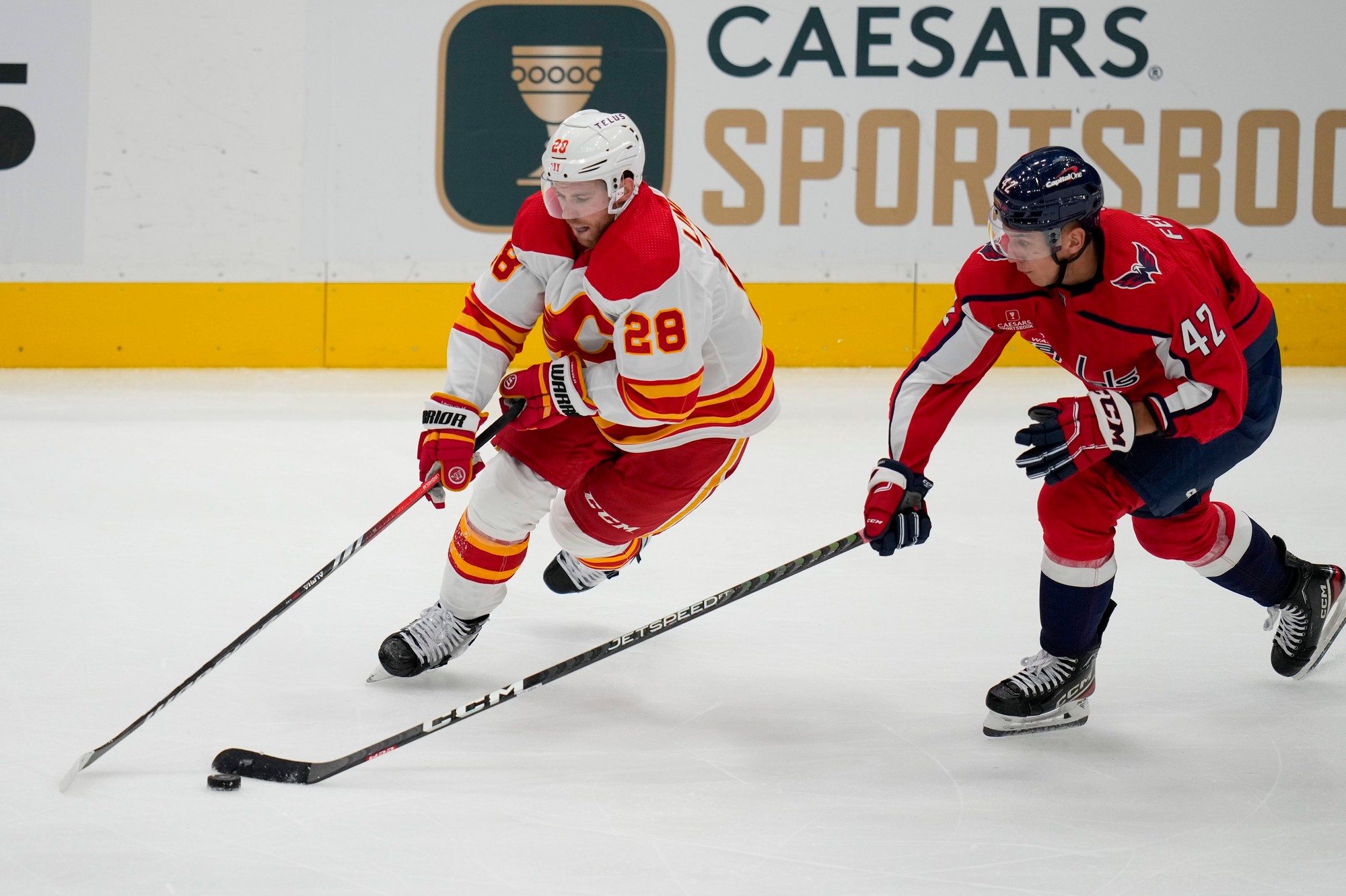 Elias Lindholm (Calgary Flames) a Martin Fehérváry (Washington Capitals).