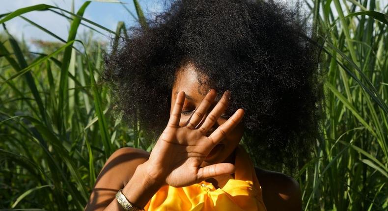 Photo of woman hiding her face using her right hand [Image: Ricaldo Donaldson]