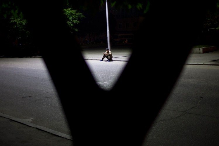 Mężczyzna czyta pod latarnią