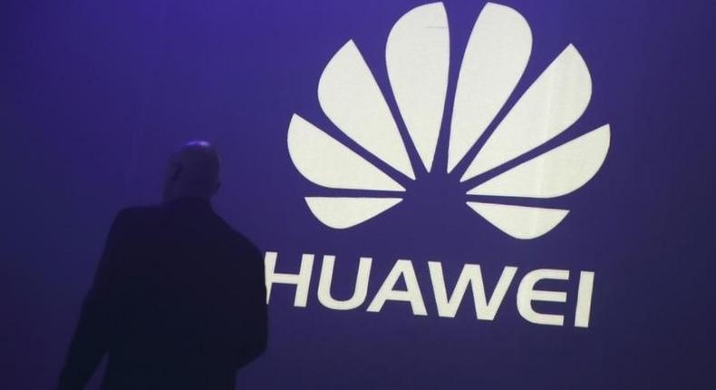 A man walks past a logo during the presentation the Huawei's new smartphone, the Ascend P7, launched by China's Huawei Technologies in Paris, May 7, 2014. REUTERS/Philippe Wojazer/Files