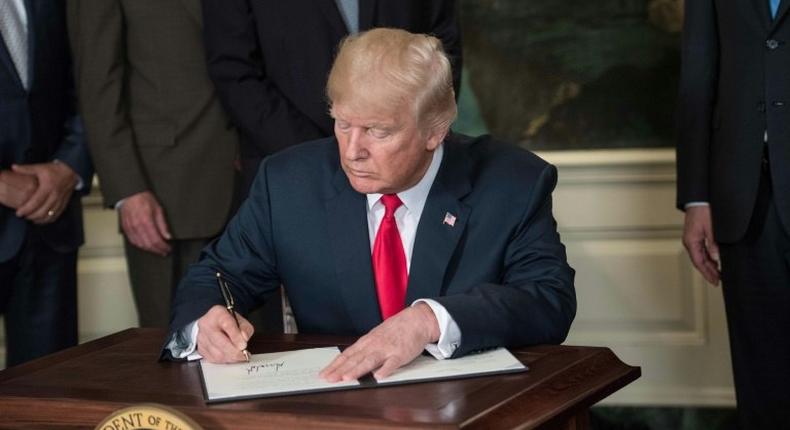 US President Donald Trump signs a memorandum on addressing China’s laws, policies, practices, and actions related to intellectual property, innovation, and technology at the White House in Washington, DC, on August 14