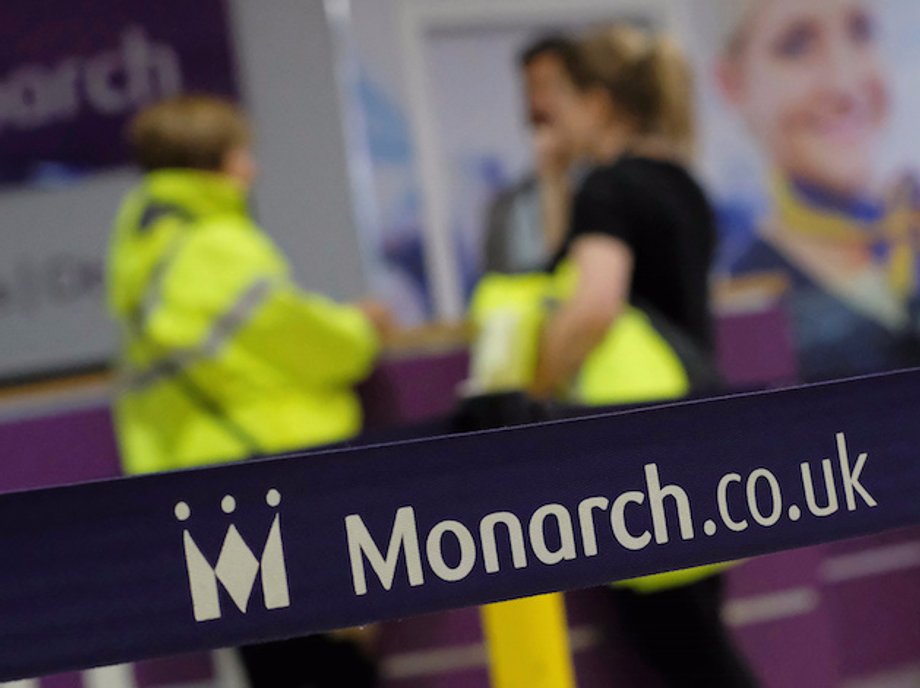 Airport staff speak by empty Monarch Airlines check-in desks after the airline ceased trading at Birmingham Airport, Britain October 2, 2017.