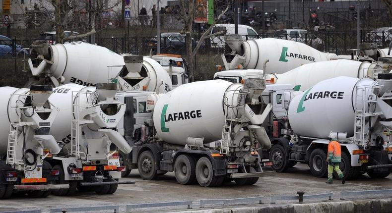Cement mixer trucks sit parked on the quay side at a Lafarge SA  (Fabrice Dimier/Bloomberg)