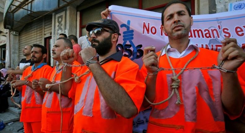 Palestinian employees of UNRWA protest against job cuts at the agency in Gaza City on September 19, 2018