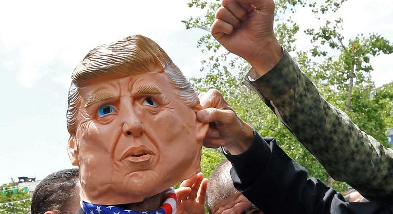 Iranians protest using a mask depicting US President Donald Trump during a rally in Tehran on May 19, 2019