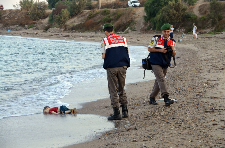 Turecka żandarmeria w pobliżu ciała Alana Kurdiego, który utonął podczas nieudanej próby przepłynięcia na grecką wyspę Kos