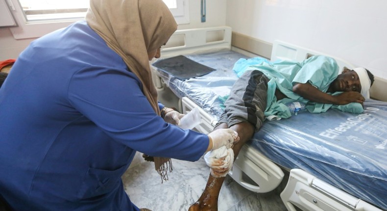 A nurse cleans the wound of a wounded migrant at a medical emergency ward in a Tripoli hospital on Wednesday