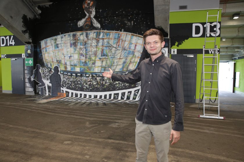 Adam Burak ze spółki Wrocław 2012 prezentuje mural na stadionie