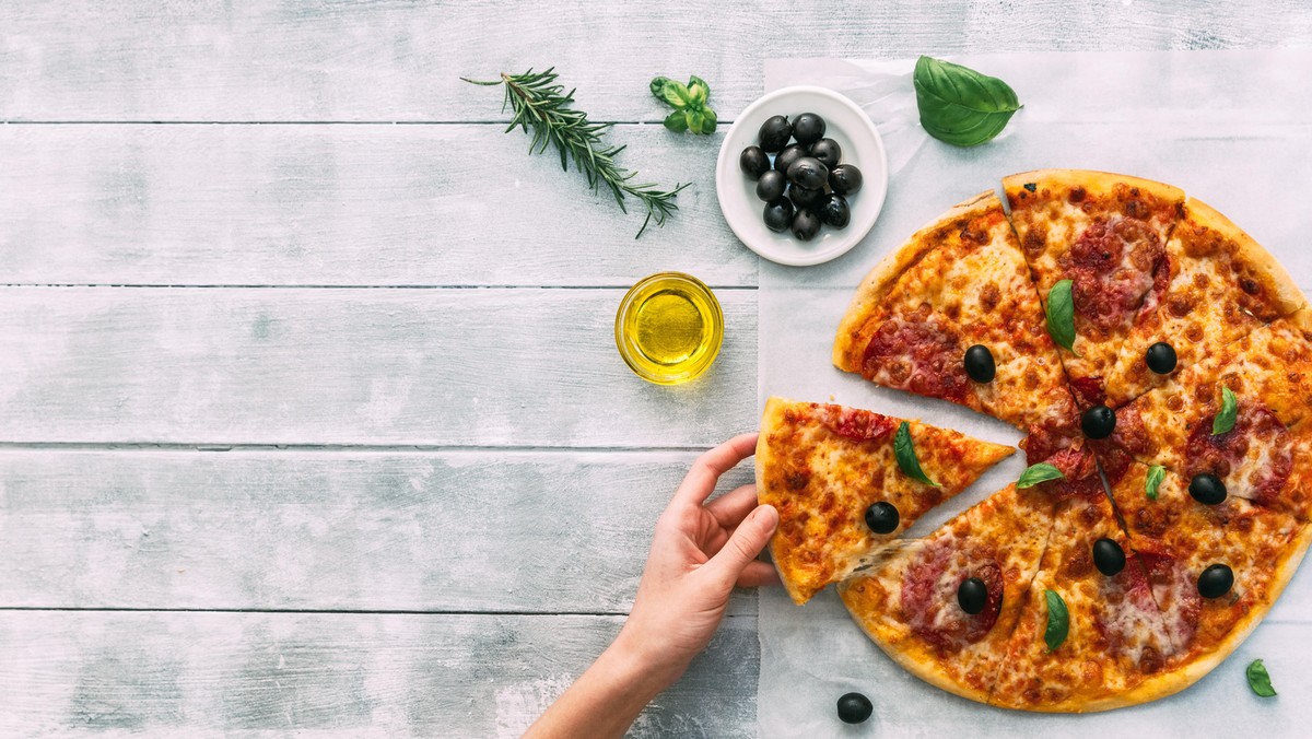 colorful tasty pizza. woman taking piece of italian pizza