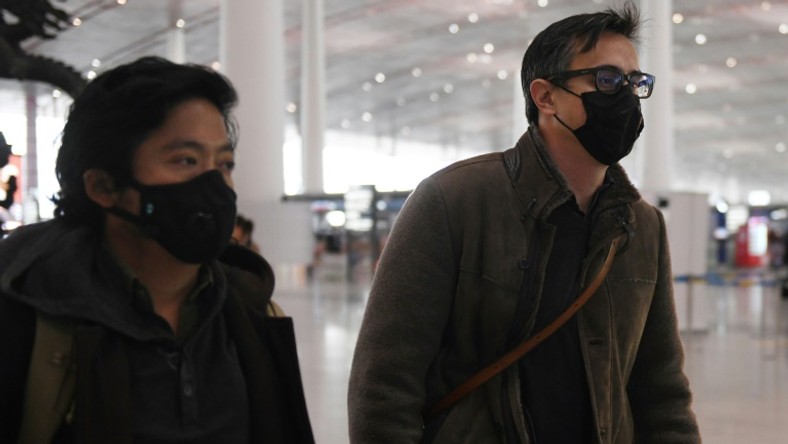 Wall Street Journal reporters Philip Wen (left) and Josh Chin walk through Beijing Capital Airport on their way out of China