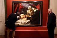 Visitors looks at a painting entitled Judith Beheading Holofernes during its presentation in Paris