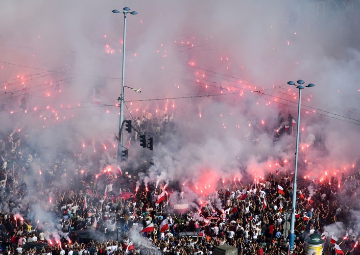 Uczestnicy marszu ONR z czerwonymi flarami podczas godziny W na rondzie Dmowskiego w Warszawie - widok z PKiN