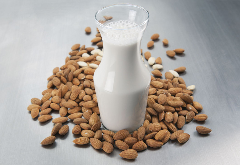 Pitcher of milk and raw almonds 