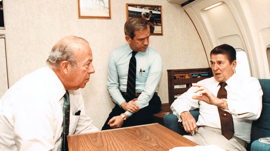 Sekretarz stanu USA George Shultz, doradca prezydenta ds. bezpieczeństwa narodowego Robert McFarlane i prezydent Ronald Reagan na pokładzie Air Force One, październik 1983 r. 