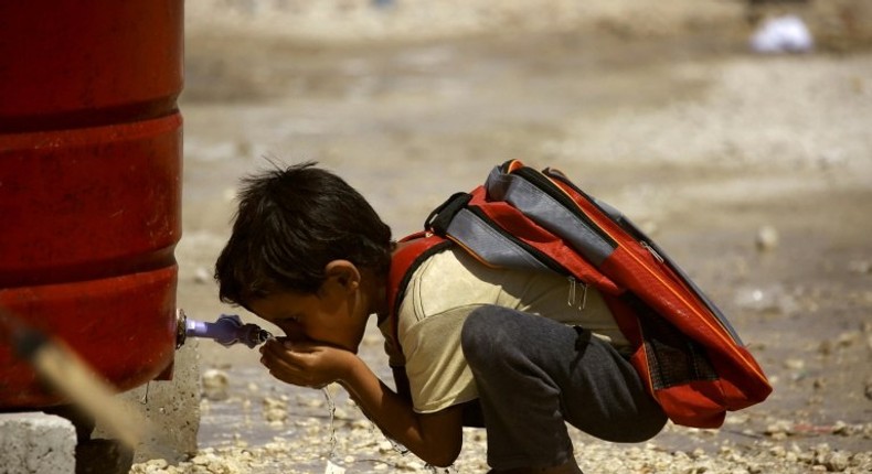 A Syrian child who has fled the Islamic State group's stronghold of Raqa, drinks water at a camp for internally displaced people in Ain Issa