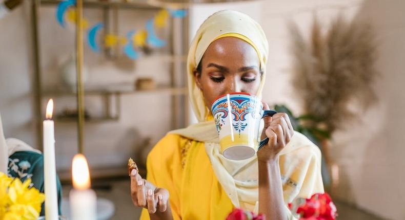 Woman in yellow hijab eating and drinking during Ramadan [Image Credit: RDNE Stock Project]