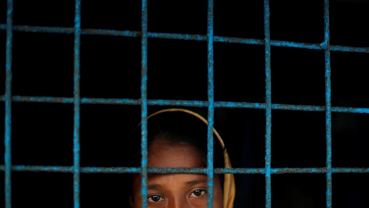 A Rohingya refugee who crossed the border from Myanmar this week stands at a window of a school used as a shelter at Kotupalang refugee camp near Cox's Bazar
