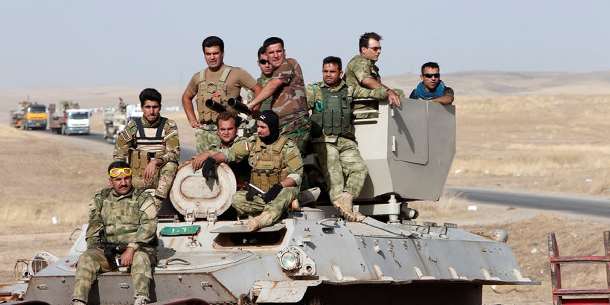 Peshmerga forces ride on military vehicles on the east of Mosul during preparation to attack Mosul, Iraq