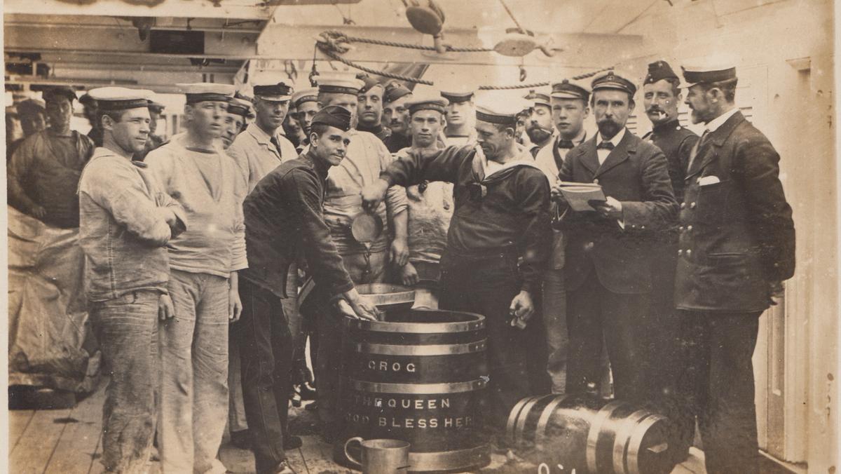Pocztówka z Portsmouth przedstawiająca marynarzy Royal Navy serwujących grog na okręcie wojennym, początek XX w.