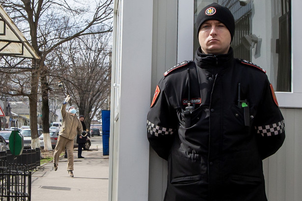 Mężczyzna wrzuca koktajl Mołotowa na teren ambasady Rosji w Kiszyniowie tuż za plecami nieświadomego strażnika