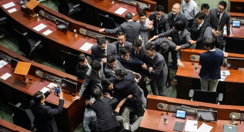 Newly elected lawmaker Baggio Leung (C in glasses) is restrained by security after attempting to read out his Legislative Council oath at Legco in Hong Kong on November 2, 2016