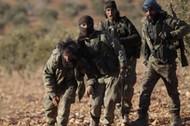 Rebel fighters help a fellow fighter, who was injured during an offensive against Islamic State fighters, on the outskirts of the northern Syrian town of al-Bab