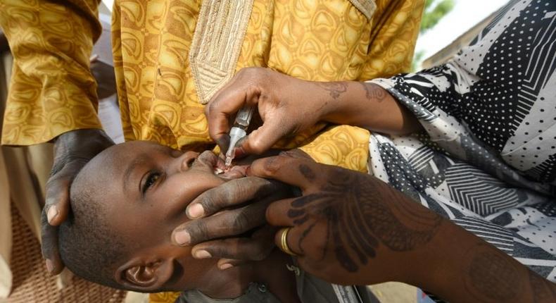 Health worker tries to immunise a child during a vaccination campaign against polio at Hotoro-Kudu, Nassarawa district of Kano in northwest Nigeria, on April 22, 2017