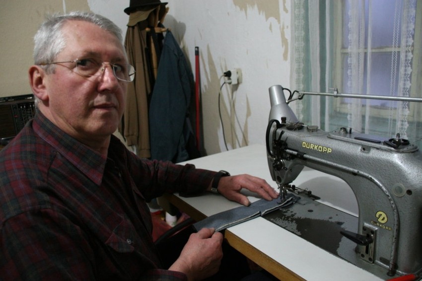 Mališa Zindović u svom domu za šivaćom mašinom i sa iglom i koncem ručno šije