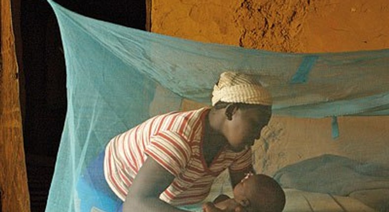 Mother and child inside a mosquito net