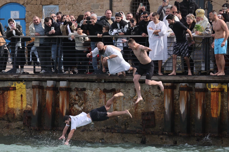Hrišćanski vernici iz grčke pravoslavne crkve Arhangela Mihaila skaču u vodu kako bi izvukli krst iz Sredozemnog mora tokom obeležavanja Bogojavljanja u Staroj luci Jafa u Tel Avivu, Izrael, 19. januara 2026. | Foto: ABIR SULTAN/EPA/Shutterstock