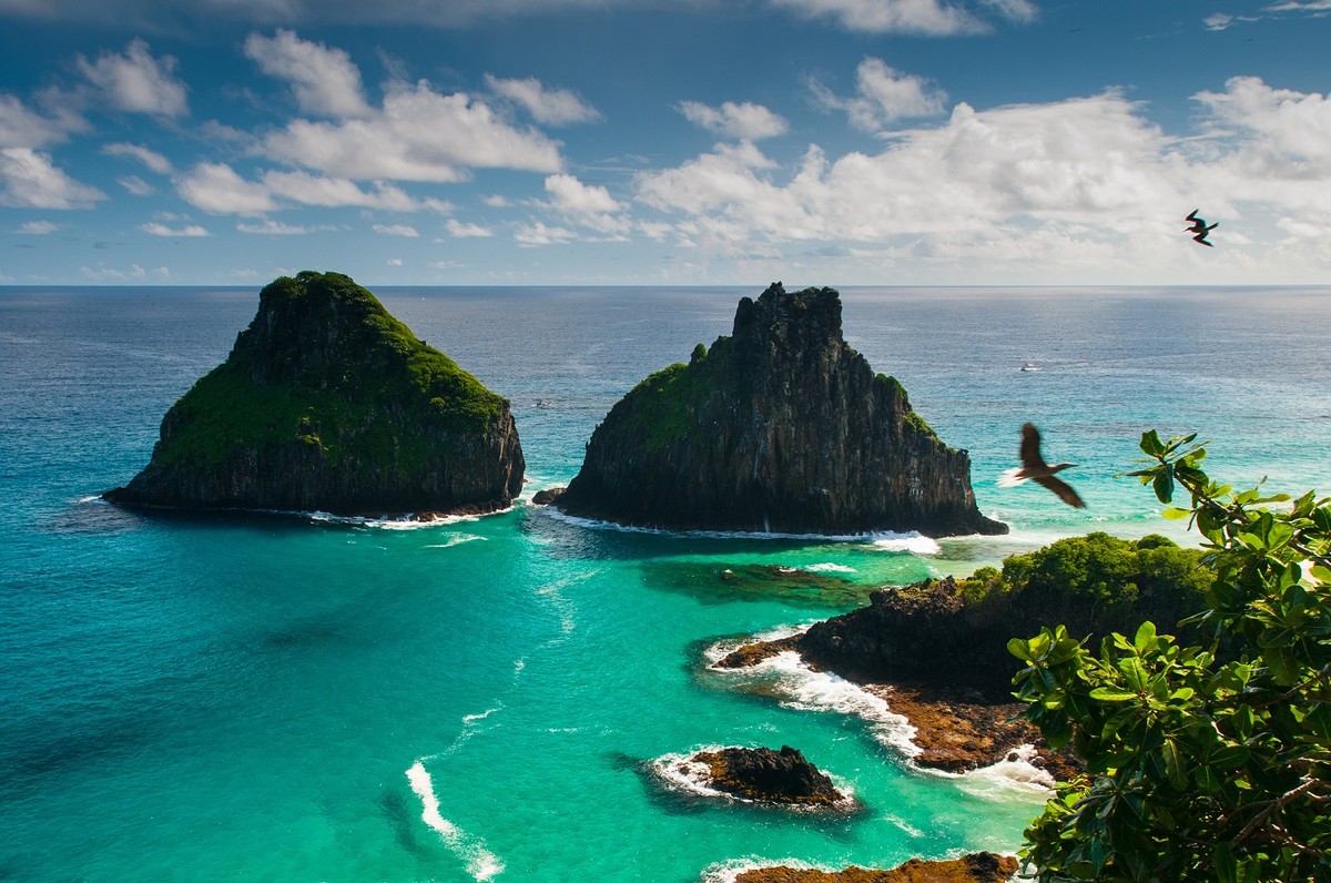Fernando de Noronha – archipelag o najpiękniejszych plażach Jeśli nie mieszkasz w Ameryce Południowej, prawdopodobnie nigdy nie słyszałeś o Fernando de Noronha. Ale jeżeli kiedykolwiek pojawi się okazja odwiedzenia tego miejsca – nie wahaj się ani przez chwilę. Fernando de Noronha jest archipelagiem 21 wysp i wysepek rozsianych na Oceanie Atlantyckim, 354 km od wybrzeża Brazylii. Ze względu na delikatny ekosystem, wpisany został na listę światowego dziedzictwa UNESCO. To miejsce to raj, którego władcami są mieszkające tu ogromne żółwie – ich wielkość sięga nawet 1,5 metra. Zwierzęta są oswojone z ludźmi, ale nie wolno ich nadto niepokoić, dlatego maksymalna ilość odwiedzających to 460 osób jednocześnie. Na archipelagu znajdują się także dwie najlepsze plaże w całej Brazylii: Praia do Leão i Baía do Sancho. Zachwyceni nimi będą nie tylko plażowicze ale i nurkowie, których zaskoczy krystalicznie czystość tutejszych wód, dających schronienie ponad dwustu gatunkom ryb, pięciu gatunkom rekinów, żółwiom morskim i delfinom. Źródło: r.pl/brazylia >>