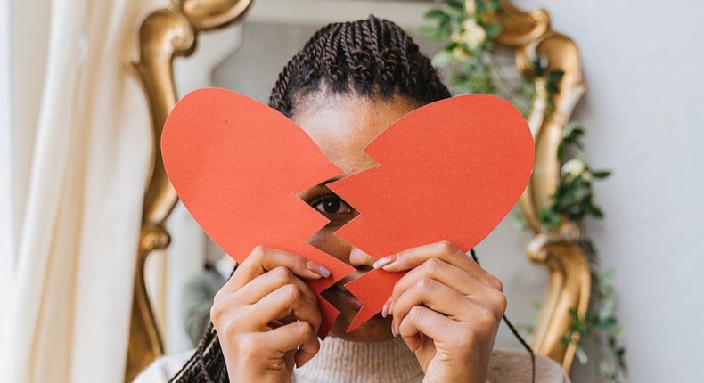 A woman holding a broken heart made of paper [Image: Antoni Shkraba]