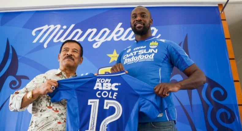 Former West Ham and Chelsea striker Carlton Cole (R) and Persib manager Umuh Muhtar hold up Cole's jersey during a press conference in Bandung, Indonesia on March 30, 2017