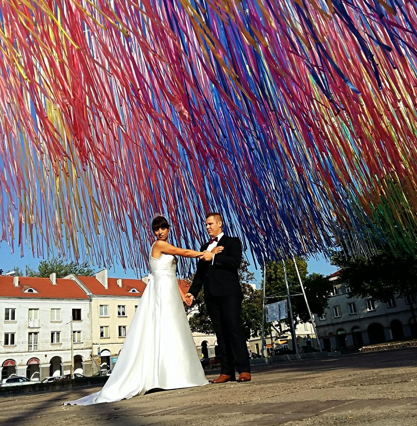 Ślubne zdjęcia pod wstążkami na Starym Rynku w Łodzi. Plener fotografii ślubnej pod instalacją Jerzego Janiszewskiego najpopularniejszy w Łodzi. Na zdjęciu autor