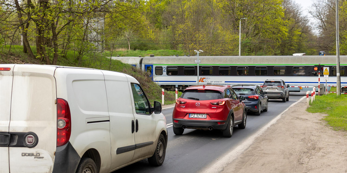 Samochody stojące na przejeździe na ul. Lutyckiej w Poznaniu.