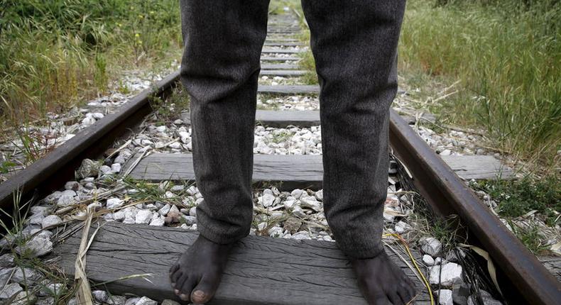 26-year-old Azam from South Sudan stands on rail tracks after failing to flee to Italy in the western Greek town of Patras April 28, 2015.   REUTERS/Yannis Behrakis