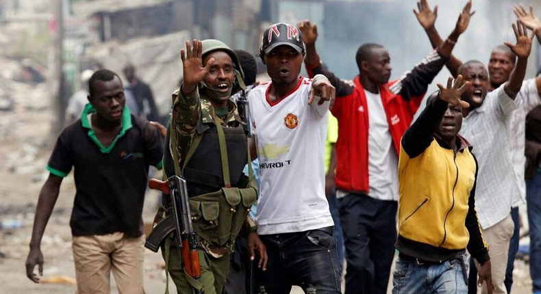 This photo of a Kenyan Policeman protecting protesters shows the other side of the Kenyan election protests