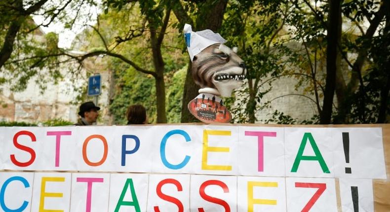 A placard reads 'Stop CETA - it's enough' during a protest against the CETA trade deal in front the Walloon parliament in Namur, Belgium on October 21, 2016