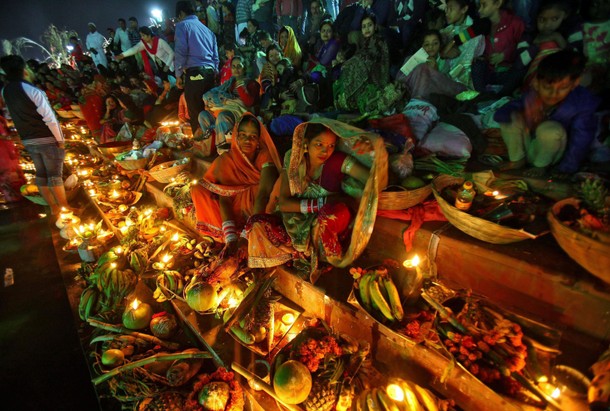 Hindu devotees gather on the banks of a lake to worship the Sun god during the Hindu religious festi