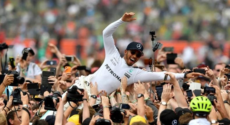 Race winner, Mercedes' British driver Lewis Hamilton, celebrates with fans after the British Formula One Grand Prix at the Silverstone motor racing circuit in central England, on July 16, 2017