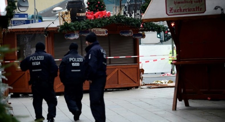 Police patrol the area near the Kaiser Wilhelm Memorial Church, where a speeding lorry crashed into a packed Berlin Christmas market, killing 12 people and injuring dozens