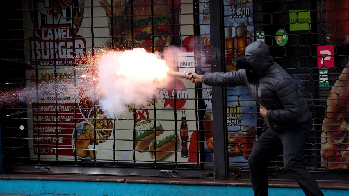 Demonstrant ispaljuje baklju tokom sukoba na protestu u Santjagu | Foto: Reuters